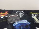 Plusieurs t-shirts « Metallichead » et un CD sont posés sur un lit