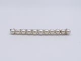 a close up of a white pearl beaded necklace on a white background