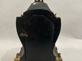 une image représentant une horloge noire et dorée posée sur une table