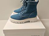 blue denim boots with white soles are on a white box