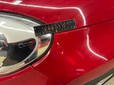 a close up of a car ' s headlight with a sticker on it
