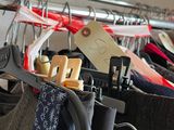 a lot of clothes hanging on a rack in a closet