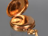 a gold pocket watch sitting on a glass table