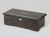 an old wooden box with a black lid and brass hardware