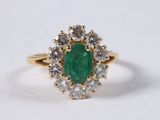 an oval emerald and diamond cluster ring
