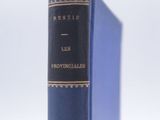 an old blue book sitting on top of a white table