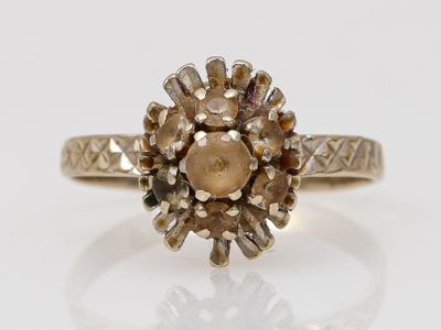 un gros plan d'une bague en or sertie d'un diamant brun