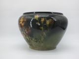 a black vase with yellow flowers in it on a white background