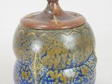 a blue and brown jar with a lid on a white surface