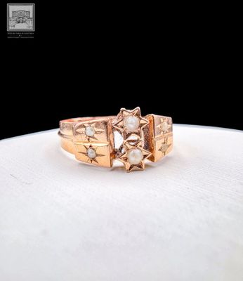 a close up of a gold ring with pearls on it