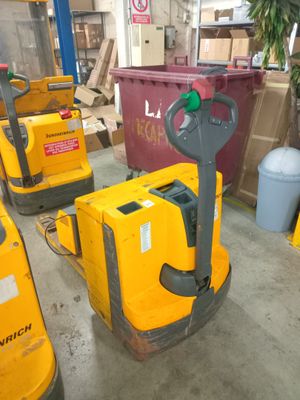 several yellow forklifts are lined up in a warehouse