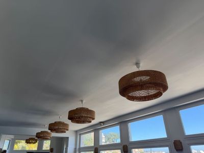 many lamps hanging from the ceiling in this room