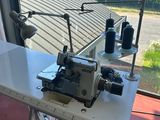 a sewing machine sitting on a table in front of a window