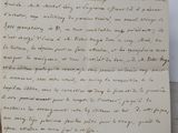an old handwritten letter on a piece of paper next to a pen