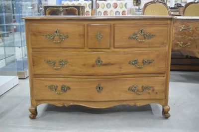 une commode en bois à nombreux tiroirs dans une pièce