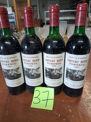 Quatre bouteilles de vin sont alignées sur une table, accompagnées d'une étiquette de prix