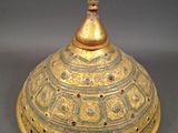 an image of a gold plate with a dome on top of it