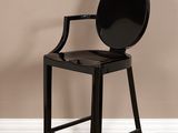 La chaise est noire et possède une assise ronde à l'arrière.