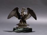 une statue représentant un aigle perché sur un socle en marbre