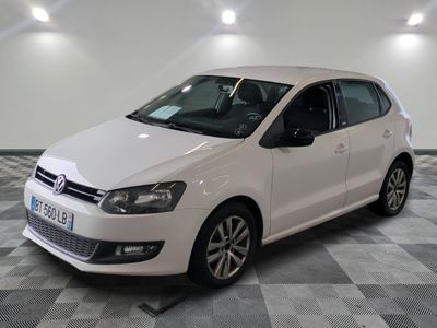 the white volkswagen polo is parked in a room with a checkered floor