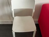 a white chair that is next to a red chair
