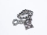 a close up of a chain with a cross and a key on it