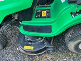 une tondeuse à gazon verte garée sur le bord de la route
