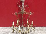 un lustre posé sur une table, avec un mur rouge en arrière-plan