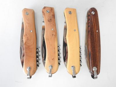 four different types of knives are lined up on a white surface
