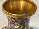 un vase posé sur une table, sur fond blanc