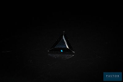 un gros plan d'un objet triangulaire dans l'obscurité