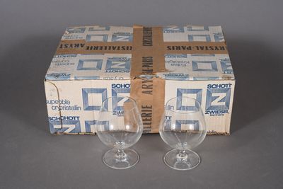 pair of empty wine glasses sitting in front of a box