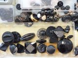many different types of black and white buttons in a box