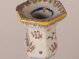 a small white vase with a yellow rim on it