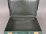 a green suitcase that is open on a white surface