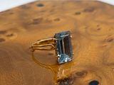 an image of a ring with a blue topaz stone in it