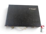 an old black book sitting on top of a table next to a knife