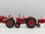 two red toy tractors are sitting side by side on a white surface