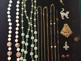 an assortment of necklaces and brooches are displayed in a display case
