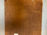 a brown piece of wood on the wall next to a black piece of paper