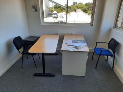 une table et deux chaises dans une pièce dotée d'une grande fenêtre