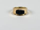 gros plan d'une bague en or contenant une pierre noire