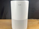 a white air purifier sitting on top of a wooden table