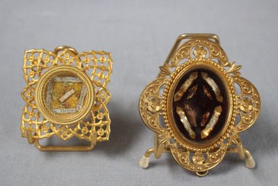 une paire de broches dorées représentant une femme en robe