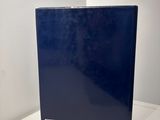 the blue book is sitting on a white table next to a white wall