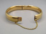 gros plan d'un bracelet en or avec une chaîne
