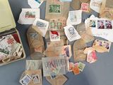 a suitcase full of stamps on the floor next to a pile of other stamps