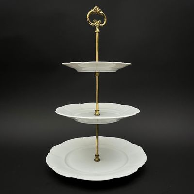 un présentoir à gâteaux à trois étages sur lequel sont posées des assiettes