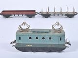 trois petits trains miniatures posés sur une surface blanche, dont l'un est posé sur l'autre