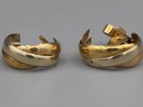paire de boucles d'oreilles dorées, avec un motif torsadé sur fond gris